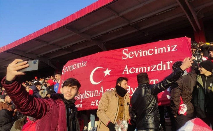 بنر حمایتی هواداران تراکتور آذربایجان از زلزله‌زدگان ترکیه؛ سئوینجینیز سئوینجیمیز، آجینیز آجیمیزدیر